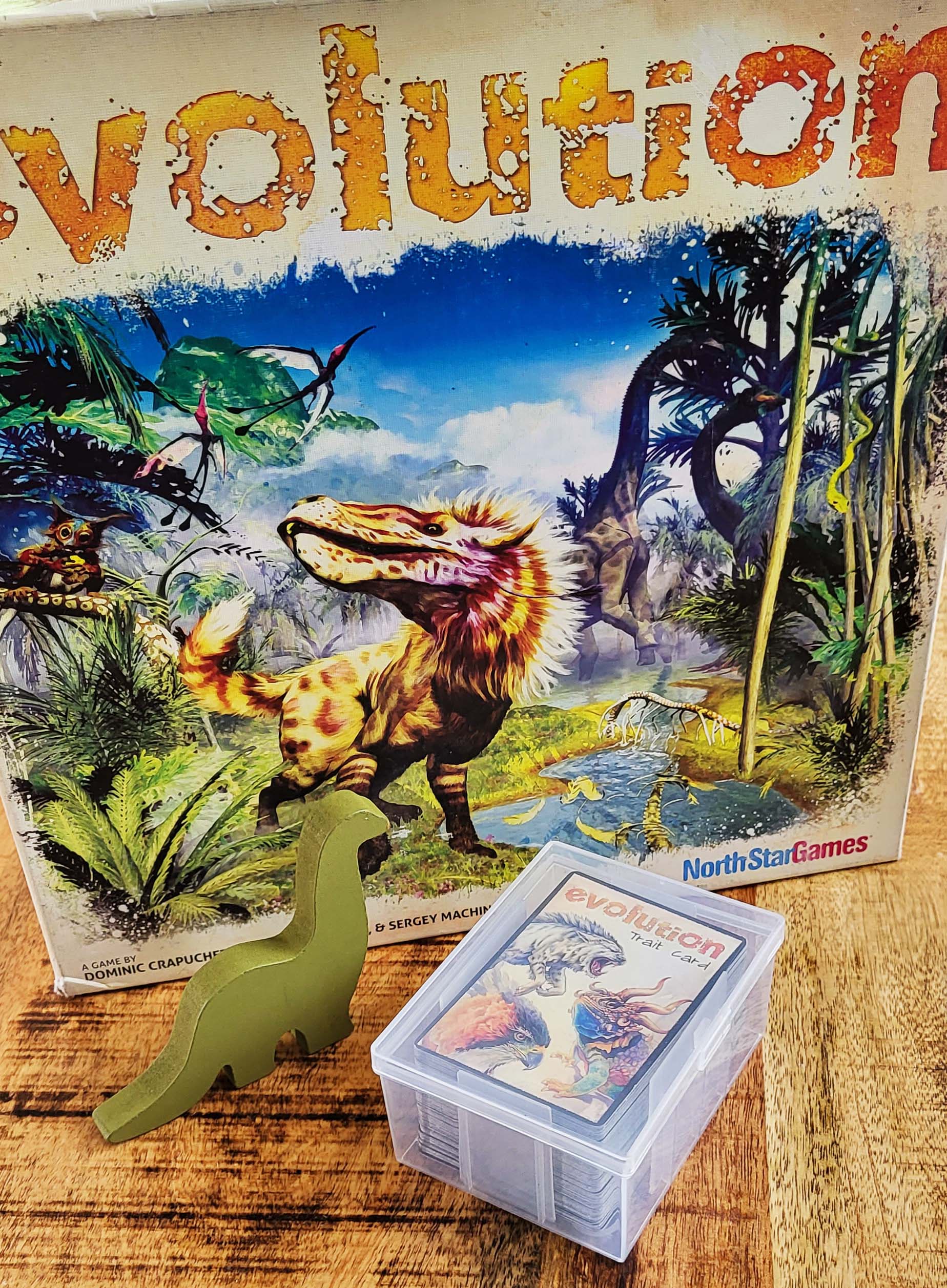 board game evolution with playing card box holding cards