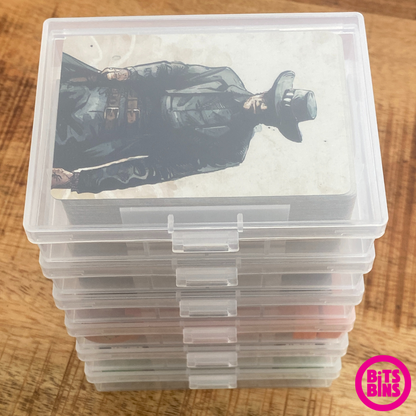 Stackable playing card deck boxes holding cards on a wood background